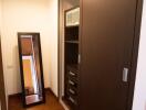 Modern hallway with large mirror and wooden flooring