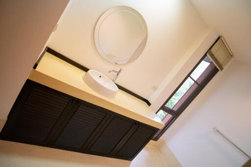 Modern bathroom with round mirror and sleek black vanity