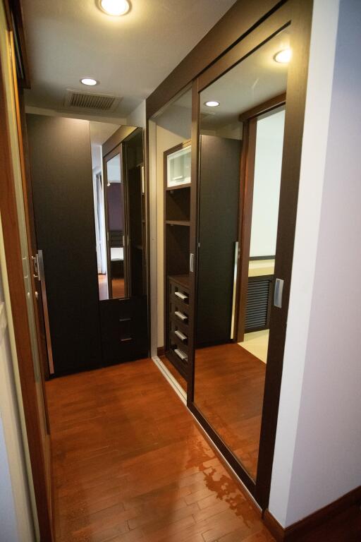 Modern bedroom with wooden flooring and mirrored closet