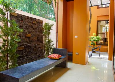 Outdoor seating area with bench, plants, and ceiling fan