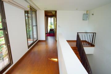 Long hallway with wooden flooring and large windows