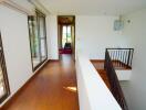 Long hallway with wooden flooring and large windows