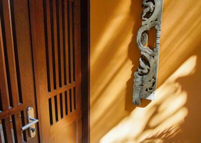 Wooden door with intricately carved decor on wall