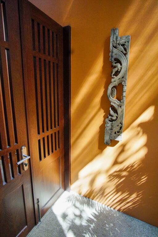 Wooden door with intricately carved decor on wall