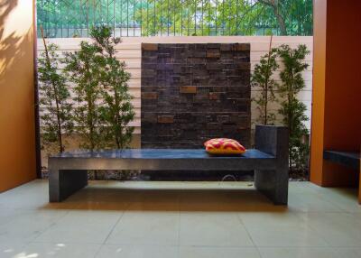 Outdoor seating area with bench and modern stone fountain