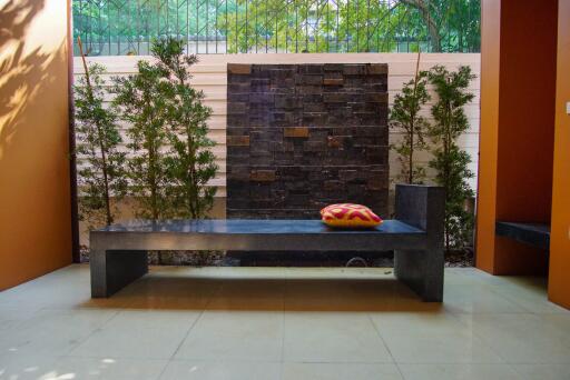 Outdoor seating area with bench and modern stone fountain