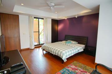 Modern bedroom with bed, window, and wooden floor