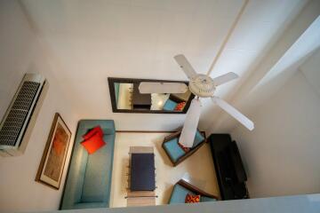 Living room with ceiling fan, couch, chairs, coffee table, and wall art