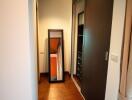 Narrow hallway with wooden floor and recessed lighting