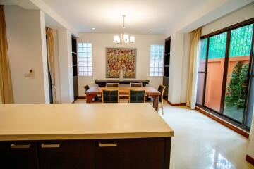 Well-lit dining room with large table and chairs near windows