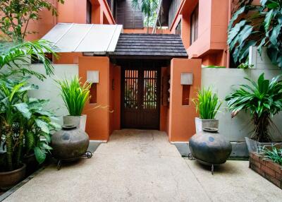 Entrance of a residential building with plants and decorative vases