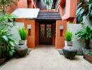 Entrance of a residential building with plants and decorative vases