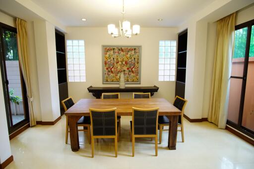 Modern dining room with wooden table and chairs, decorative artwork on the wall