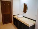 Modern bathroom with single vanity and circular mirror