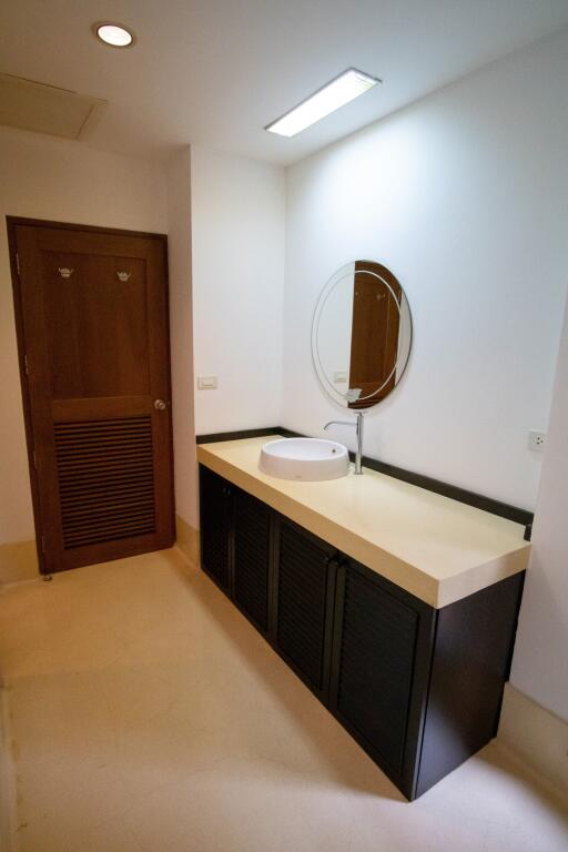 Modern bathroom with single vanity and circular mirror