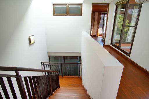 Bright staircase area with wooden flooring and large windows