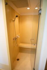 Shower area with glass door and overhead lights