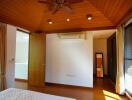 Spacious bedroom with wooden ceiling and ceiling fan