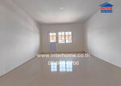 Empty room with tiled floor, large window and white walls