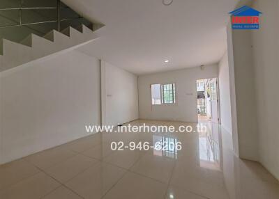 Spacious and Empty Living Area with Window and Staircase