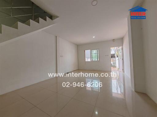 Spacious and Empty Living Area with Window and Staircase