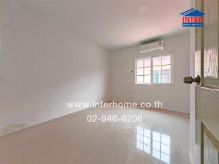 Small empty bedroom with a white wall, air conditioner, window, and tiled floor