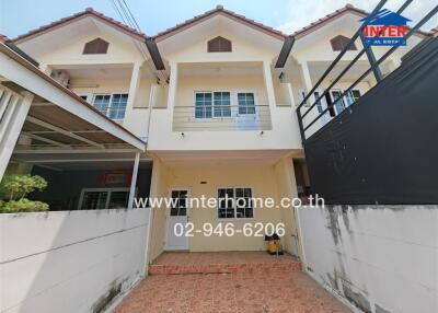 Front view of a residential building with two stories and a tiled courtyard