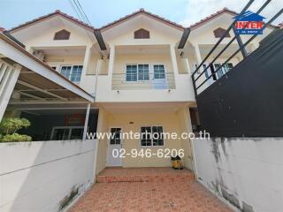 Front view of a residential building with two stories and a tiled courtyard