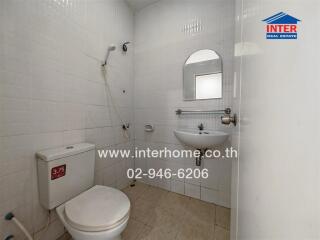 Bathroom with modern fixtures, toilet, showerhead, sink, and mirror