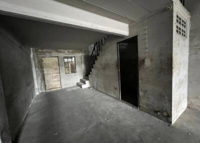 Empty basement with stairs and concrete flooring