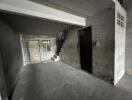 Empty basement with stairs and concrete flooring