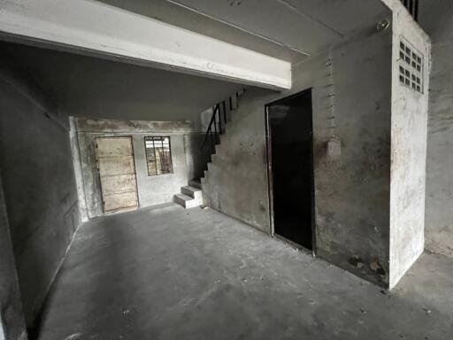 Empty basement with stairs and concrete flooring