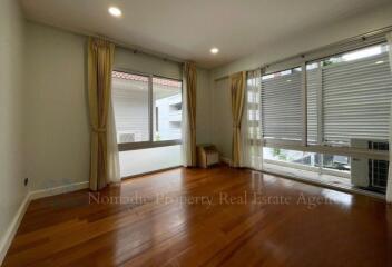 Spacious living room with wooden flooring and large windows