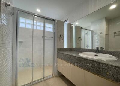 Modern bathroom with glass shower enclosure and large mirror