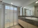 Modern bathroom with glass shower enclosure and large mirror