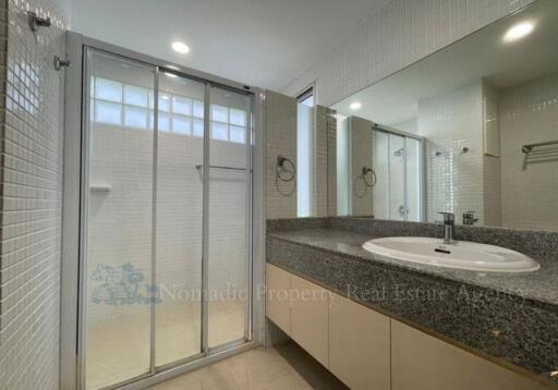 Modern bathroom with glass shower enclosure and large mirror