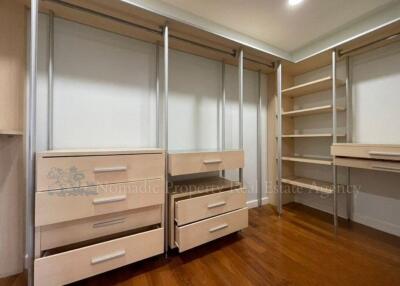 Spacious walk-in closet with built-in shelves and drawers