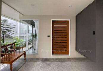 Main entrance with wooden door and sitting area