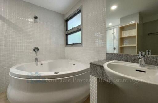 Bathroom with a freestanding bathtub, sink and window