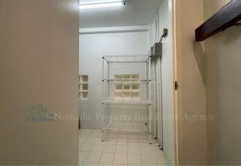 Utility room with white tile flooring and metal storage shelves