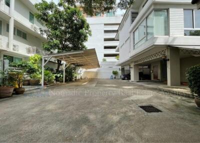 Exterior view of a residential building with parking area and garden