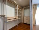 Spacious walk-in closet with built-in wooden drawers and shelving