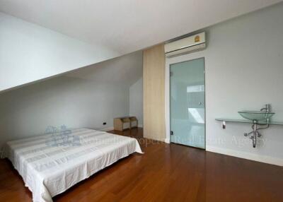 Spacious bedroom with wooden floor and modern amenities