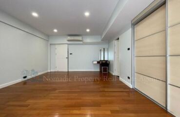 Spacious living room with wooden flooring and ample natural light