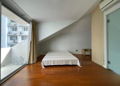 Minimalist bedroom with large windows and wooden floor