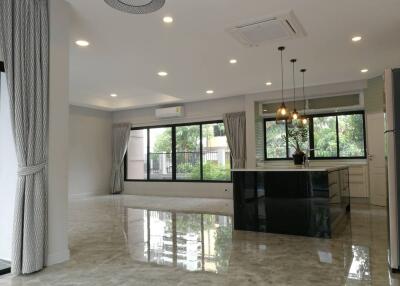 Spacious kitchen and dining area with modern design, large windows, and marble flooring