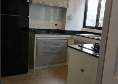 Modern kitchen with black fridge and white cabinets