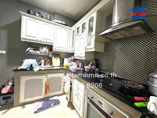 Modern kitchen with white cabinetry and various appliances