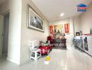 Living room with white tiled flooring, a cabinet with religious items, and a framed picture on the wall