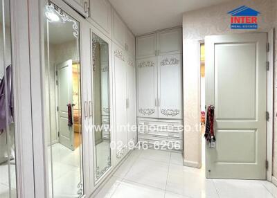 Well-lit bedroom with mirrored wardrobe and white furniture